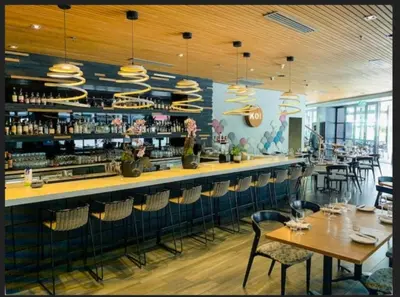 a restaurant with a bar with tables and chairs at Menlyn Maine Luxury Apartments in Pretoria