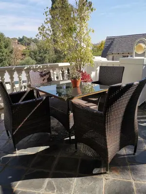 a patio with a table and chairs on a balcony at Erasmus manor Guest House in Pretoria