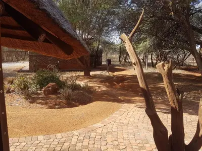 a wooden pole on a brick walkway in a park at Sondela Nature Reserve & Spa Moselesele Tents in Bela-Bela