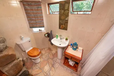 a bathroom with a toilet and a sink at Shumba Safari Bush Camp in Hoedspruit