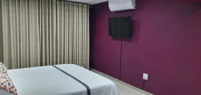 a room with a bed and a purple wall at TERTIUS LODGE in Nelspruit