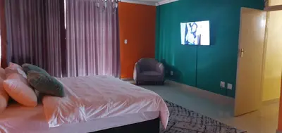 a bedroom with a bed and a green wall at TERTIUS LODGE in Nelspruit