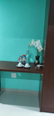 a table with white flowers on a blue wall at TERTIUS LODGE in Nelspruit