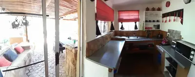 a room with a kitchen with a table and a couch at Kiburi Cottage @ Kruger in Marloth Park
