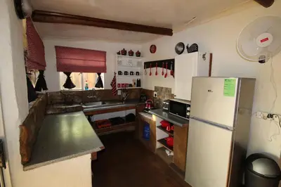 a kitchen with a white refrigerator and a sink at Kiburi Cottage @ Kruger in Marloth Park