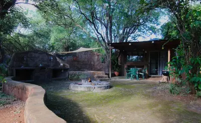 a backyard with a fire pit in the yard at Kiburi Cottage @ Kruger in Marloth Park