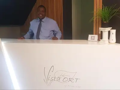 a man in a tie standing behind a counter at Vista ORT in Kempton Park