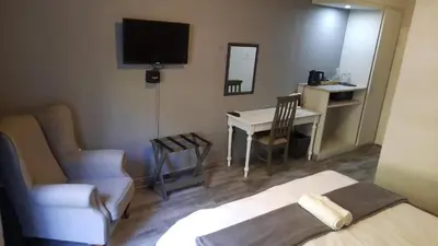 a room with a bed and a chair and a desk at Vista ORT in Kempton Park