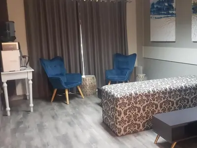 a living room with two blue chairs and a couch at Vista ORT in Kempton Park