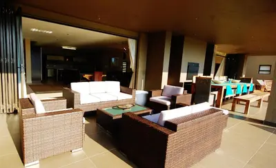 a lobby with wicker chairs and tables and a dining room at Legend Golf and Safari Resort in Sterkrivier