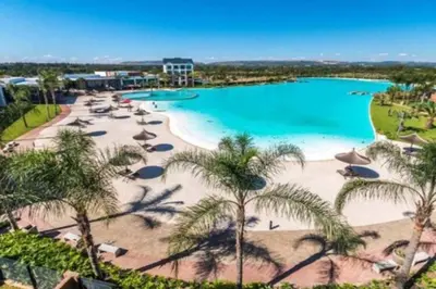 an aerial view of a beach with umbrellas and a pool at THE BLYDE CRYSTAL LAGOON BEACH PRETORIA in Pretoria