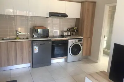 a kitchen with a washing machine and a washer at THE BLYDE CRYSTAL LAGOON BEACH PRETORIA in Pretoria