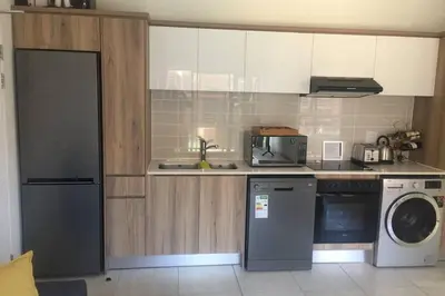 a kitchen with a washing machine and a washer at THE BLYDE CRYSTAL LAGOON BEACH PRETORIA in Pretoria