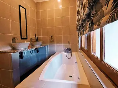 a bathroom with two sinks and a large tub at Wildnut Lodge and Game Farm in Louis Trichardt
