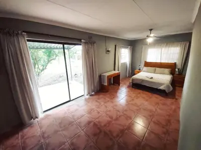 a bedroom with a bed and a large window at Wildnut Lodge and Game Farm in Louis Trichardt