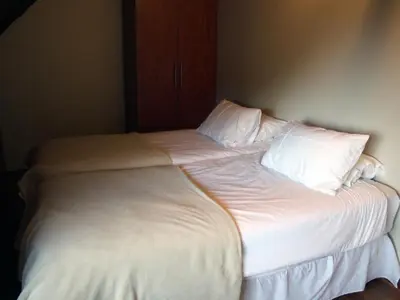 a large white bed with white sheets and pillows at Wildnut Lodge and Game Farm in Louis Trichardt