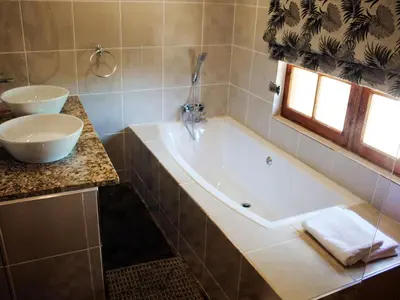 a bathroom with a tub and a sink at Wildnut Lodge and Game Farm in Louis Trichardt