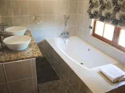 a bathroom with a bath tub and a sink at Wildnut Lodge and Game Farm in Louis Trichardt