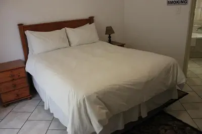 a bed with white sheets and pillows in a bedroom at El Palmar Guesthouse in Groblersdal