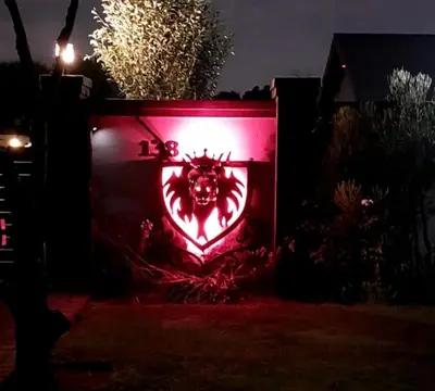 a red wall with a symbol on it at The Royal Prime Guest Lodge in Centurion