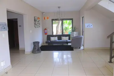 a living room with a couch and a chair at Oasis Hotel in Mokopane