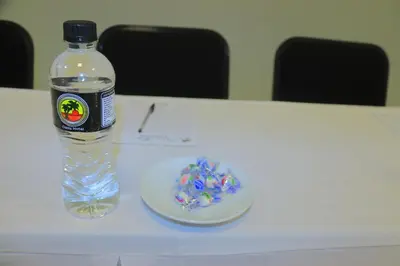 a bottle of water and a plate on a table at Oasis Hotel in Mokopane