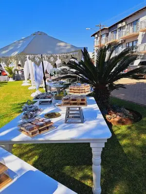 a long white table with chairs and a palm tree at Oasis Hotel in Mokopane