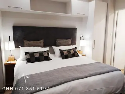a bedroom with a large bed with a large headboard at Regency Apartment in Pretoria