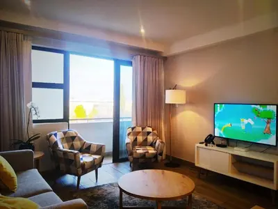 a living room with a couch and a tv at Regency Apartment in Pretoria
