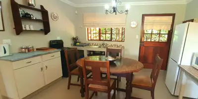 a kitchen with a wooden table and a dining room at Schaefers' Halt in Dullstroom