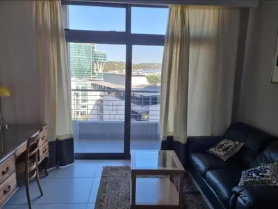 a living room with a couch and a large window at Menlyn Maine Apartments in Pretoria