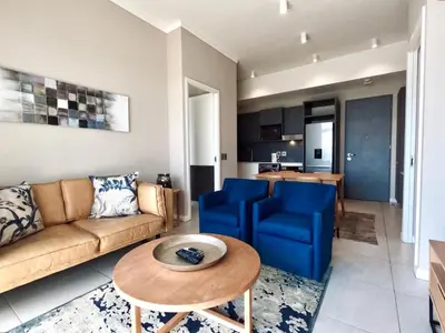 a living room with a couch and a table at Menlyn Maine Apartments in Pretoria