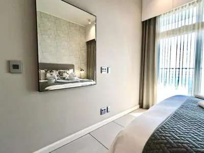 a bedroom with a large mirror on the wall at Menlyn Maine Apartments in Pretoria