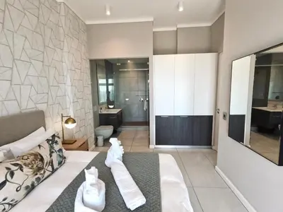 a hotel room with a bed and a bathroom at Menlyn Maine Apartments in Pretoria