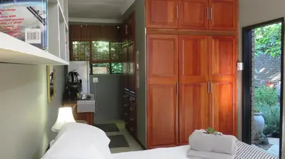 a bedroom with a large wooden closet and a bed at Beni Apartment in Pretoria