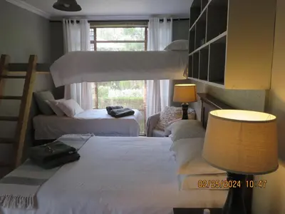 a bedroom with two bunk beds and a window at Beni Apartment in Pretoria