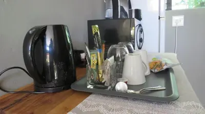 a tray with utensils on a table with a coffee maker at Beni Apartment in Pretoria