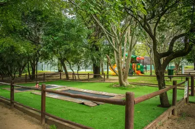 a wooden fence in a park with a playground at INYAMATANE LUXURY LODGES at Kruger Park Lodge in Hazyview