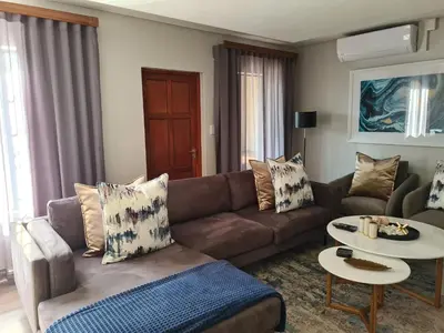 a living room with a couch and a table at Villa Casa Lifestyle in Nelspruit