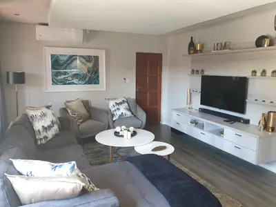 a living room with a couch and a tv at Villa Casa Lifestyle in Nelspruit