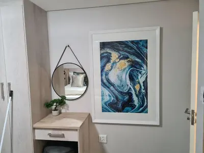 a bathroom with a mirror and a painting on the wall at Villa Casa Lifestyle in Nelspruit