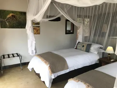 a bedroom with two beds and a canopy at 11 Raptors Lodge in Hoedspruit