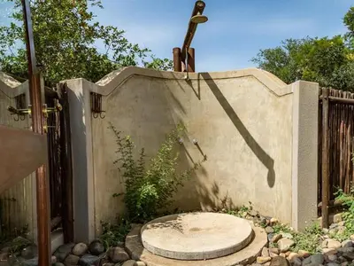 a concrete wall with a fence and a gate at 11 Raptors Lodge in Hoedspruit