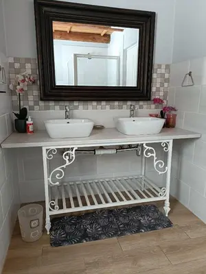 a bathroom with two sinks and a mirror at Sedgefield Lodge in Witbank