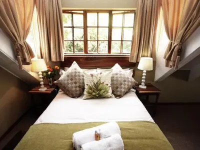 a bedroom with a bed with two lamps and a window at Bellstone B&B in Pretoria