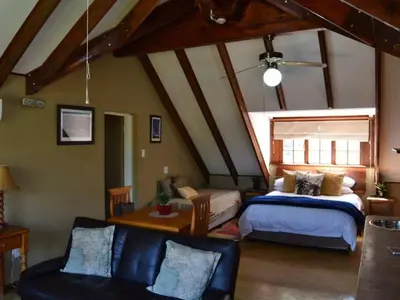 a bedroom with a bed and a couch in a room at Bellstone B&B in Pretoria