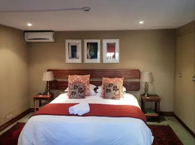 a bedroom with a large bed with white sheets and pillows at Bellstone B&B in Pretoria