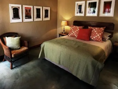 a bedroom with a bed and a chair at Bellstone B&B in Pretoria