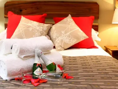 a bed with towels and champagne bottles on it at Bellstone B&B in Pretoria