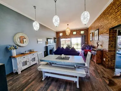 a living room with a table and a couch at Dullstroom Manor Game & Trout Lodge in Dullstroom